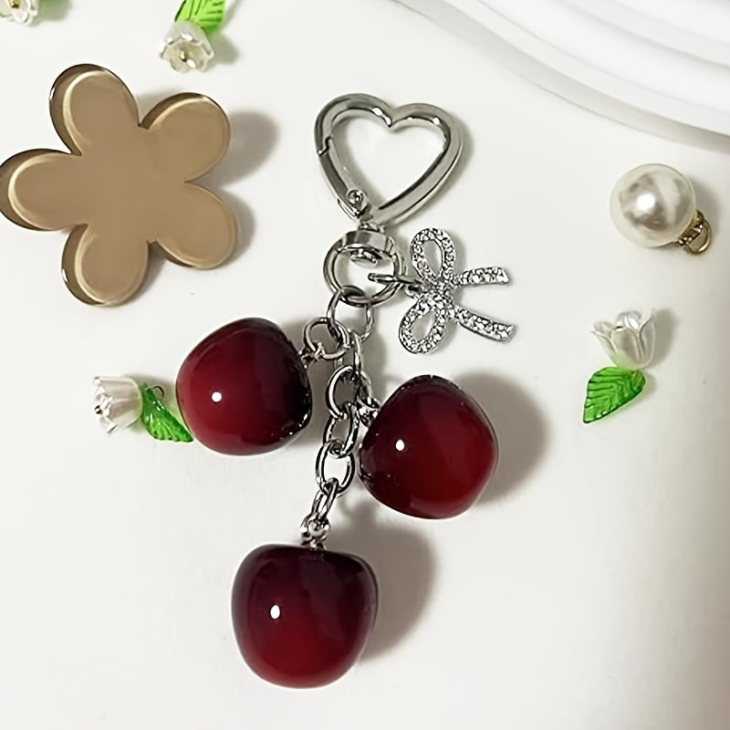 Portachiavi a forma di ciliegia con fiocco e ciondolo a forma di cuore - Resina rossa, finiture dorate - Ideale per borse da donna, portafogli, accessori per San Valentino, ciondolo per borsa a forma di ciliegia