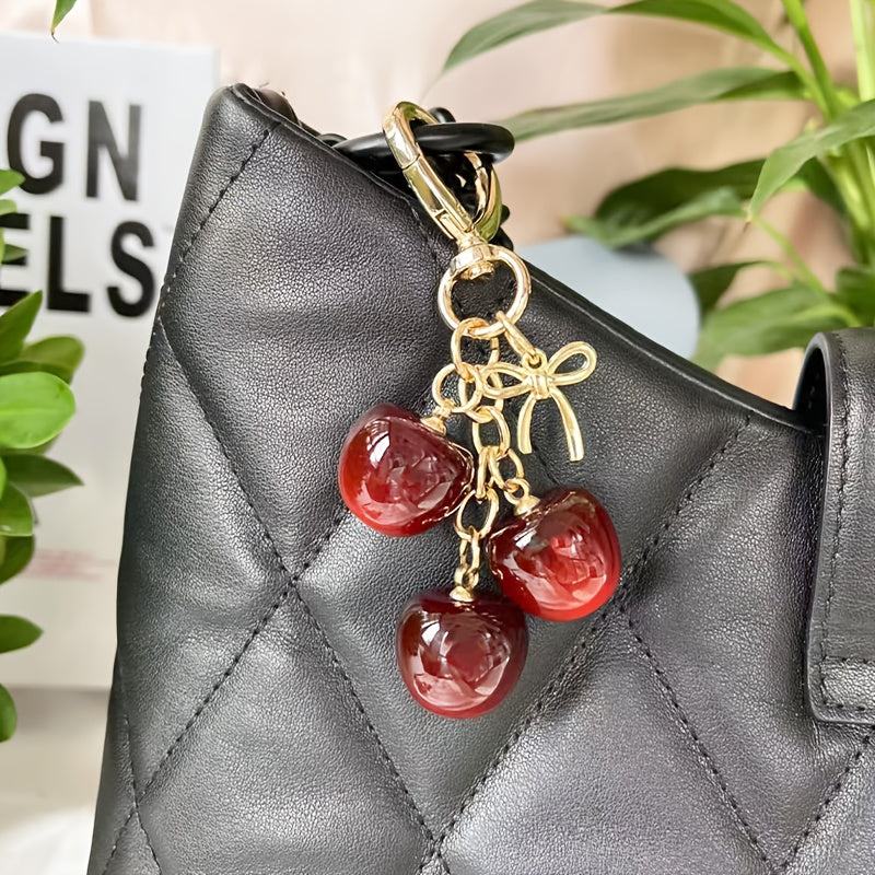 Portachiavi a forma di ciliegia con fiocco e ciondolo a forma di cuore - Resina rossa, finiture dorate - Ideale per borse da donna, portafogli, accessori per San Valentino, ciondolo per borsa a forma di ciliegia